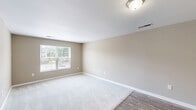 Located at 134 Wolfetrail Rd in Greensboro, NC, this single-floor, 2-bedroom, 2-bathroom home offers a clean, functional layout designed for comfortable everyday living. The combined kitchen and living area serves as the heart of the home, with the kitchen featuring rich dark cabinetry, light countertops, wood-look flooring, and white appliances including a refrigerator, electric range, built-in microwave, and dishwasher. Track lighting adds a practical touch overhead. The living area transitions seamlessly, with soft carpet underfoot and a large window that invites natural light and neighborhood views. Both bedrooms are carpeted and finished in warm neutral tones, each with windows providing natural light. The spacious primary bedroom includes ample room for furnishings, while both bedrooms are served by dedicated closets equipped with wire shelving systems for organized storage. A hallway connects the bedroom wing to the rest of the home. The two bathrooms are clean and functional, each featuring a full tub-shower combination with chrome fixtures. Consistent neutral wall tones, white trim, and carpet throughout lend the home a cohesive, move-in-ready aesthetic.