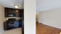 Located at 43 Strathmore Gardens, this single-floor residence offers a thoughtfully designed layout with a cohesive blend of modern finishes and classic details throughout. Rich hardwood flooring flows through the living areas and bedrooms, adding warmth and continuity to the space.

The kitchen is a functional highlight, featuring dark espresso-toned cabinetry that extends to the ceiling for ample storage, granite-style countertops, a tile backsplash, and a full suite of black GE appliances including a gas range, microwave, dishwasher, and refrigerator. Light tile flooring completes the kitchen's clean, contemporary look.

The living and dining areas are generously sized and filled with natural light streaming through large windows dressed with blinds and vertical panel curtains. A chandelier adds a refined touch, while baseboard heating and wall-mounted air conditioning units provide year-round comfort.

The bedrooms are bright and well-proportioned, each with hardwood floors, natural light from windows, and access to closet storage. One bedroom features a spacious reach-in closet with hanging rods.

The bathroom is elegantly finished with floor-to-ceiling neutral tile, a tub-shower combination enclosed by a sliding glass door, a built-in shower niche, and a window for natural ventilation — creating a clean and spa-like atmosphere.
