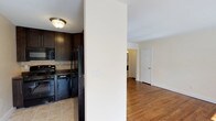 Located at 43 Strathmore Gardens, this single-floor residence offers a thoughtfully designed layout with a cohesive blend of modern finishes and classic details throughout. Rich hardwood flooring flows through the living areas and bedrooms, adding warmth and continuity to the space.

The kitchen is a functional highlight, featuring dark espresso-toned cabinetry that extends to the ceiling for ample storage, granite-style countertops, a tile backsplash, and a full suite of black GE appliances including a gas range, microwave, dishwasher, and refrigerator. Light tile flooring completes the kitchen's clean, contemporary look.

The living and dining areas are generously sized and filled with natural light streaming through large windows dressed with blinds and vertical panel curtains. A chandelier adds a refined touch, while baseboard heating and wall-mounted air conditioning units provide year-round comfort.

The bedrooms are bright and well-proportioned, each with hardwood floors, natural light from windows, and access to closet storage. One bedroom features a spacious reach-in closet with hanging rods.

The bathroom is elegantly finished with floor-to-ceiling neutral tile, a tub-shower combination enclosed by a sliding glass door, a built-in shower niche, and a window for natural ventilation — creating a clean and spa-like atmosphere.