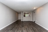 Located at 3400 Winterset Pkwy SE in Marietta, Georgia, this single-floor residence offers a clean, modern aesthetic throughout. The open living area is highlighted by rich dark hardwood-style flooring, a textured ceiling, and a tile-surround fireplace flanked by windows that bring in natural light, creating a warm and inviting atmosphere.

The kitchen is well-appointed with white shaker-style cabinetry, white subway tile backsplash, light countertops, and a full suite of stainless steel appliances including a gas range, over-the-range microwave, and dishwasher. Wood-style flooring continues seamlessly through this space.

The bedrooms feature plush carpeting, ceiling fans with light fixtures, and generous closet space with bifold doors. One bedroom includes a sliding glass door providing access to an outdoor area and additional natural light. Each bedroom benefits from window blinds for privacy and light control.

The bathrooms are finished with white vanity cabinetry, brushed nickel hardware, quartz-style countertops, and wood-style flooring. The full bathroom includes a tub-shower combination with tiled surround. The overall design palette of neutral grays, whites, and warm wood tones gives the entire unit a cohesive, contemporary feel.