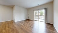 Located at 2065 Marlowe Blvd in St. Charles, IL, this three-bedroom residence offers a well-designed single-floor layout with a clean, modern aesthetic throughout. Warm hardwood-style flooring runs continuously across all rooms, creating a cohesive and inviting atmosphere.

The galley-style kitchen is outfitted with dark espresso cabinetry, white countertops, and a full suite of stainless steel appliances, including a gas range, built-in microwave, refrigerator, and dishwasher. Recessed lighting adds a polished finish to the space.

The open living room is bright and airy, featuring a sliding glass door that leads to a private balcony with outdoor views of surrounding greenery — an ideal spot for relaxing or entertaining. The neutral wall tones and natural light enhance the sense of openness throughout.

Three bedrooms provide comfortable, versatile living spaces. The generously sized primary bedroom offers ample room for furnishings, while the additional bedrooms are well-proportioned and naturally lit through large windows. Each room features the same warm flooring and clean white walls that define the home's consistent style.

A hallway connects the living areas to the bedrooms, contributing to an efficient and functional floor plan. The overall design is modern, minimalist, and move-in ready.