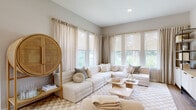 Located on Rainbow Chase Road in Davenport, Florida, this single-story residence showcases a cohesive contemporary design defined by a warm neutral palette, light wood-tone finishes, and consistent wood-look flooring throughout. The entryway sets an inviting tone with louvered doors, a rounded decorative mirror, and a console table that transitions seamlessly into the open living areas beyond.

The kitchen is outfitted with light wood cabinetry, crisp white upper cabinets, quartz countertops, a subway tile backsplash, and stainless steel appliances. A central island provides additional workspace, while a window above the sink allows natural light to filter in. Pendant lighting with matte black globe fixtures adds a modern finishing touch.

The living room is bright and generously proportioned, featuring large windows with views of lush greenery, roller shades, and floor-length linen drapes. The bedroom features a cane-frame bed, large windows with outdoor views, and ample natural light. A spacious walk-in closet with wire shelving provides practical storage. The bathroom includes a wood-tone vanity, quartz countertop, and a tiled tub-shower combination. Throughout, the interiors maintain a calm, refined ambiance well-suited to the Florida lifestyle.