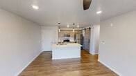 This contemporary 820 square foot apartment offers a thoughtful blend of style and functionality. The heart of the home is an open-concept living area, seamlessly integrating the kitchen and living room. The kitchen boasts light wood cabinetry, stainless steel appliances, and a spacious island with a stylish countertop, perfect for casual dining or entertaining.

The apartment features two bedrooms, including a primary bedroom of 140 square feet, both equipped with plush carpeting and ceiling fans for comfort. Large windows in the bedrooms and living area flood the space with natural light and offer picturesque views. One bedroom even includes sliding glass doors leading to a private balcony, extending the living space outdoors.

Two well-appointed bathrooms complement the bedrooms, featuring modern fixtures and clean lines. The apartment's design emphasizes a neutral color palette, with white walls and warm wood-look flooring in the main living areas, creating a bright and inviting atmosphere.

Additional amenities include a closet for storage, air conditioning units for climate control, and contemporary lighting fixtures throughout. The combination of hardwood-style floors in the living areas and carpet in the bedrooms adds texture and warmth to the space. This apartment offers a perfect balance of comfort and modern design in a compact yet well-utilized 820 square feet.
