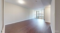 Located at 44 Lisgar St in Toronto's vibrant Queen West neighbourhood, this thoughtfully laid-out unit offers a comfortable and functional single-floor living experience. Rich dark hardwood flooring flows throughout the main living areas, providing a warm contrast to the neutral grey walls and white trim.

The spacious living room is a standout feature, anchored by expansive floor-to-ceiling windows and a sliding glass door that opens to a balcony, flooding the space with natural light and offering open views of the surrounding Toronto cityscape. The bright, airy atmosphere makes the living area feel generously proportioned.

The galley-style kitchen is efficiently designed, featuring dark espresso cabinetry with sleek bar-pull hardware, granite-look countertops, a stainless steel sink, and black appliances including a full-size refrigerator. Light ceramic tile flooring completes the kitchen's clean, functional aesthetic.

The bedroom is well-sized with large windows that bring in abundant natural light and urban views. A set of sliding mirrored closet doors provides practical built-in storage. The adjacent bathroom features a navy blue vanity with a mirror and warm lighting.

A textured ceiling is consistent throughout the unit, adding architectural character. This unit combines modern finishes with a practical layout in one of Toronto's most walkable and dynamic neighbourhoods.