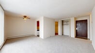 Located at 17599 Whitney Rd in Strongsville, Ohio, this 2-bedroom, 1-bathroom unit offers a practical, single-floor layout designed to maximize functionality within a compact footprint. The living room serves as the central gathering space, featuring light gray carpet, a textured ceiling, a wall-mounted air conditioning unit, and a large sliding glass door dressed with vertical blinds that invites natural light and provides outdoor views. Baseboard heating runs along the exterior walls, supplementing climate control throughout the unit.

The galley-style kitchen is efficiently arranged with warm oak cabinetry extending to the ceiling, offering generous storage. White appliances including a range, dishwasher, and refrigerator line one wall, while a countertop with an undermount sink occupies the opposite side. Wood-look flooring and a ceiling fan complete the kitchen's practical design.

Both bedrooms are carpeted and finished in neutral tones, each featuring a built-in closet with double doors and hanging rods for organized storage. The primary bedroom includes a wall A/C unit and a large window with vertical blinds. The full bathroom offers a tub-shower combination with white tile surround, a wood-vanity with a light countertop, and wood-look flooring, maintaining a clean and functional aesthetic throughout.