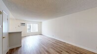 Located at 504 S La Fayette Park Pl, Unit 205, in the heart of Los Angeles, this studio unit offers a thoughtfully arranged single-floor layout that maximizes its cozy footprint. The combined kitchen and living area forms the core of the unit, bathed in natural light from a large window fitted with vertical blinds and a wall-mounted air conditioning unit for year-round comfort. Light-toned wood-look flooring runs throughout, lending warmth and visual continuity to the space, while textured popcorn ceilings add a classic touch overhead.

The kitchen is efficiently designed with an L-shaped layout, featuring white cabinetry both above and below the counter, marble-patterned laminate countertops, a stainless steel sink, and a white range, providing ample storage and workspace. A breakfast bar-style partition separates the kitchen from the living area, creating a natural division within the open-concept floor plan.

Two closets offer generous storage for a unit of this scale, while a full bathroom completes the interior. The clean white walls throughout the unit provide a neutral canvas adaptable to a variety of interior styles. This unit is well-suited for those seeking a practical and centrally located residence in Los Angeles.