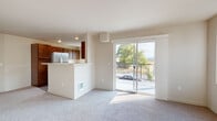 Located at 701 N Conklin Road in Spokane Valley, WA, Unit B207 is a thoughtfully designed single-floor residence that offers a comfortable and functional layout. The open-concept living area is bright and welcoming, featuring plush carpeting and large sliding glass doors that lead to a private balcony with outdoor views of mature trees and the surrounding neighborhood. Natural light flows generously throughout the space, enhancing its clean, neutral palette.

The kitchen is efficiently designed with rich, warm-toned cabinetry, light countertops, and a full suite of stainless steel appliances including a refrigerator, range, built-in microwave, and dishwasher. Wood-look flooring adds a practical yet attractive finish to the kitchen area. A peninsula counter connects the kitchen to the living space, creating a convenient pass-through ideal for everyday use.

The bedrooms are carpeted and well-lit, each featuring windows that invite natural light and views of the greenery outside. Ample closet space is provided, including a walk-in closet accessible from the hallway. The bathrooms are finished with wood-look tile flooring, dark wood vanity cabinetry, and light countertops, offering a clean and modern aesthetic. The hallway connecting the rooms is equipped with recessed lighting, contributing to the overall bright and airy feel of the unit.