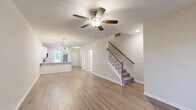 Located at 106 Copper Ridge Rd in Evans, GA, this two-story home offers a well-designed layout spread across two floors. The main level, which comprises the majority of the living space, features an open-concept floor plan connecting the living room, dining area, and kitchen. Rich hardwood-style flooring flows throughout the main level, complemented by neutral walls and recessed lighting. The living room is anchored by a fireplace and a ceiling fan, while a classic staircase with a wood banister leads to the upper floor. The kitchen stands out with white shaker-style cabinetry, granite countertops, a tile backsplash, stainless steel appliances, and a peninsula with seating — ideal for casual dining. Four bathrooms serve the home, including clean, bright full baths with tub/shower combinations, tile flooring, and granite-topped vanities. A dedicated laundry room and multiple closets add practical convenience. Upstairs, the bedrooms feature plush carpeting and ceiling fans, with the primary bedroom offering natural light through large windows. The second floor connects efficiently via a hallway. Overall, the home presents a clean, move-in-ready aesthetic with modern finishes throughout.