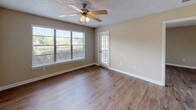 Located at 3339 Handy Rd in Tampa, FL 33618, this single-story unit offers a practical and well-maintained layout with consistent wood-style flooring throughout. The main living area is bright and open, featuring a ceiling fan with light fixture, a textured ceiling, and a large window fitted with horizontal blinds that allows ample natural light to fill the room. An additional area provides direct outdoor access through a full-length sliding glass door dressed with vertical blinds, offering a seamless connection to the outside.

The kitchen is outfitted with white cabinetry featuring brushed nickel hardware, light-toned countertops, a double stainless steel sink, and a black dishwasher, providing functional workspace in a clean, neutral aesthetic.

The bathroom is efficiently designed, featuring a white vanity with a cultured marble countertop and integrated sink, a large mirror, overhead cabinetry for storage, and a full-sized soaking tub with a tiled shower surround. The flooring in the bathroom continues the wood-style theme found throughout the rest of the unit.

Overall, the space presents a clean, move-in-ready environment with neutral wall tones, white trim, and consistent finishes that create a cohesive and practical living environment in the heart of Tampa.