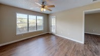 Located at 3339 Handy Rd in Tampa, FL 33618, this single-story unit offers a practical and well-maintained layout with consistent wood-style flooring throughout. The main living area is bright and open, featuring a ceiling fan with light fixture, a textured ceiling, and a large window fitted with horizontal blinds that allows ample natural light to fill the room. An additional area provides direct outdoor access through a full-length sliding glass door dressed with vertical blinds, offering a seamless connection to the outside.

The kitchen is outfitted with white cabinetry featuring brushed nickel hardware, light-toned countertops, a double stainless steel sink, and a black dishwasher, providing functional workspace in a clean, neutral aesthetic.

The bathroom is efficiently designed, featuring a white vanity with a cultured marble countertop and integrated sink, a large mirror, overhead cabinetry for storage, and a full-sized soaking tub with a tiled shower surround. The flooring in the bathroom continues the wood-style theme found throughout the rest of the unit.

Overall, the space presents a clean, move-in-ready environment with neutral wall tones, white trim, and consistent finishes that create a cohesive and practical living environment in the heart of Tampa.