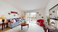 Located at 4398 Rainier Way in Oceanside, California, this single-floor home offers four bedrooms and two full bathrooms within a well-organized, efficiently designed layout. The living room serves as the heart of the home, featuring plush carpeted flooring, generous natural light, and a sliding glass door that opens to a private balcony with outdoor views — ideal for enjoying the Southern California climate. The combined dining area sits adjacent to the living space and includes a ceiling fan overhead, creating a comfortable and casual setting for meals. The kitchen is equipped with light wood cabinetry, granite-style countertops, tile flooring, and standard appliances including an electric range and over-the-range microwave. The four bedrooms are carpeted and well-lit by natural light through large windows. The primary bedroom offers a comfortable footprint, while secondary bedrooms feature built-in sliding-door closets for convenient storage. Both bathrooms are finished with tile flooring, wood vanities with granite-style countertops, and large mirrors. One bathroom includes a walk-in shower, while the other offers a full tub-shower combination. The overall aesthetic is clean and bright, with a consistent neutral palette throughout.