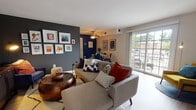 Located at 550 S DuPont Parkway in New Castle, Delaware, this single-floor residence offers a thoughtfully designed layout with a cohesive mid-century modern aesthetic throughout. The open-concept living and dining area serves as the heart of the home, anchored by a dramatic charcoal accent wall adorned with a curated gallery of framed artwork. Large sliding glass doors flood the living space with natural light and provide direct access to a private outdoor balcony, offering views of the surrounding area. A ceiling fan adds both function and character to this welcoming gathering space.

The dining area is defined by a rich navy accent wall, creating an intimate atmosphere that pairs well with the space's clean lines and warm wood tones. The kitchen features warm honey-toned cabinetry, tile flooring, and full appliances including an electric range and built-in microwave.

The bedrooms are generously proportioned, each with its own distinct personality. The primary bedroom showcases a bold terracotta accent wall and features dual closets, providing ample storage. A second bedroom offers soft carpet, natural light through curtained windows, and closet access. The full bathroom includes a tiled tub-shower combination, a single vanity with white cabinetry, and tile flooring.