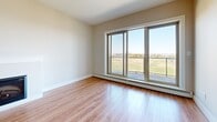 Located at 15 Bently Drive in Halifax, Nova Scotia, this well-designed one-bedroom, one-bathroom unit offers a comfortable and functional layout across a single floor. The entry hallway features light tile flooring and clean neutral walls, providing a welcoming transition into the living areas. The open-concept kitchen and living room form the heart of the unit, where warm hardwood-style flooring extends throughout. The kitchen is equipped with rich dark-stained wood cabinetry, dark granite countertops, a stainless steel range and dishwasher, and a tile floor—offering both style and practicality. The living room is highlighted by a sleek fireplace and large sliding glass doors that flood the space with natural light and open to sweeping outdoor views of the surrounding landscape. The generously sized bedroom continues the hardwood-style flooring and benefits from a large window with scenic views, creating a bright and restful retreat. The full bathroom mirrors the kitchen's design aesthetic with matching wood vanity, dark granite countertop, and a full soaker tub with shower. A dedicated laundry room with a full-sized washer and dryer adds everyday convenience to complete this thoughtfully appointed home.