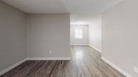 Located at 2225 Nursery Rd in Clearwater, Florida, this single-floor residence offers a well-organized layout designed for comfortable everyday living. The open living area features wood-look plank flooring in a warm gray tone, neutral-painted walls with crisp white baseboards, and a textured ceiling that runs throughout the main living spaces. A sliding glass door floods the living room with natural light and provides access to an outdoor area, enhancing the airy feel of the space.

The kitchen is thoughtfully appointed with white shaker-style cabinetry, granite-look countertops, and a full suite of black appliances, including a refrigerator, electric range, over-the-range microwave, and dishwasher. A window above the sink adds natural light to this functional workspace.

The bedrooms are carpeted for comfort and finished with the same neutral color palette. Each room includes closet space — one featuring a sliding-door closet with a hanging rod — providing practical storage solutions. The bathroom is clean and bright, outfitted with a white vanity, large mirror, and a shower/tub combination, all set over wood-look flooring that ties seamlessly into the rest of the home. The overall ambiance is fresh, move-in ready, and well-suited for a variety of lifestyles.