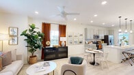 Located at 2626 Goose Island Dr in Leland, NC, this two-story home offers a thoughtfully designed layout with stylish finishes throughout. The main level features an open-concept living and dining area filled with natural light from multiple windows. The living room is a welcoming space with a ceiling fan, recessed lighting, and a warm, neutral palette complemented by rich burnt-orange drapery. It flows seamlessly into a dedicated dining area and a well-equipped kitchen. The kitchen showcases sage-toned shaker-style cabinetry, white quartz countertops, a subway tile backsplash, and stainless steel appliances including a side-by-side refrigerator and electric range. Light wood-look flooring ties the main living spaces together. A convenient half bath on the main level features a pedestal sink and brushed nickel fixtures. Upstairs, the primary bedroom is generously sized with multiple windows, a ceiling fan, plush carpeting, and a walk-in closet with wire shelving. Additional bedrooms also feature carpeted floors, closet storage, and ample natural light. A full bathroom upstairs includes a walk-in tiled shower, a single-sink vanity with white countertops, and decorative curtain accents. Throughout the home, clean lines and bright interiors create a comfortable and functional living environment.