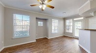 Located at 8585 Woodway Dr in Houston, TX, this one-bedroom, one-bathroom residence offers a thoughtfully designed single-floor layout. The living room is a welcoming space featuring warm wood-style flooring, crown molding, a ceiling fan with light kit, and multiple windows dressed with blinds that allow generous natural light and views of the surrounding greenery. A built-in niche adds a subtle architectural detail to the living area.

The kitchen is well-appointed with dark espresso cabinetry, granite countertops, stainless steel appliances including a refrigerator, electric range, microwave, and dishwasher, plus glass-front upper cabinets that add a refined touch. Wood-style flooring continues throughout the kitchen for a cohesive aesthetic.

The bedroom offers a comfortable retreat with plush carpeting, a ceiling fan, a natural light-providing window, and two closets for ample storage. The bathroom includes dark cabinetry with overhead storage, granite countertops, and wood-style flooring. Two hallways and additional closet space contribute to practical storage throughout.

The building exterior features manicured landscaping, mature trees, and gated access, providing a serene residential setting in the heart of Houston.
