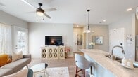 This thoughtfully designed 3-bedroom, 2-bathroom single-floor residence offers a cohesive open-concept layout that seamlessly connects the kitchen, dining, and living areas. The kitchen is a standout feature, equipped with rich dark cabinetry, stainless steel appliances, a textured tile backsplash, and a generous granite island with pendant lighting and bar seating — ideal for both everyday meals and entertaining. Light wood-style flooring runs throughout the main living areas, contributing to a warm, contemporary aesthetic.

The living room is bright and inviting, benefiting from natural light through large windows and a glass door that opens to the exterior. A ceiling fan adds both comfort and style to the space. The bedrooms are carpeted and tranquil, each with natural light and neutral tones, including a well-proportioned primary bedroom. The two bathrooms offer distinct finishes: one features a spacious double vanity with dark cabinetry, wood-look flooring, and a walk-in shower, while the second includes a classic tub-shower combination with clean, bright finishes. Throughout, the neutral color palette, recessed lighting, and modern fixtures create a cohesive and comfortable living environment.