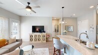 This thoughtfully designed 3-bedroom, 2-bathroom single-floor residence offers a cohesive open-concept layout that seamlessly connects the kitchen, dining, and living areas. The kitchen is a standout feature, equipped with rich dark cabinetry, stainless steel appliances, a textured tile backsplash, and a generous granite island with pendant lighting and bar seating — ideal for both everyday meals and entertaining. Light wood-style flooring runs throughout the main living areas, contributing to a warm, contemporary aesthetic.

The living room is bright and inviting, benefiting from natural light through large windows and a glass door that opens to the exterior. A ceiling fan adds both comfort and style to the space. The bedrooms are carpeted and tranquil, each with natural light and neutral tones, including a well-proportioned primary bedroom. The two bathrooms offer distinct finishes: one features a spacious double vanity with dark cabinetry, wood-look flooring, and a walk-in shower, while the second includes a classic tub-shower combination with clean, bright finishes. Throughout, the neutral color palette, recessed lighting, and modern fixtures create a cohesive and comfortable living environment.
