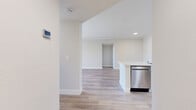 Located at 11100 4th St in Rancho Cucamonga, CA, this well-appointed 2-bedroom, 2-bathroom residence offers a thoughtfully designed single-level layout with a clean, modern aesthetic. The open-concept living and kitchen area serves as the heart of the home, featuring light wood-look flooring, crown molding, and a ceiling fan. A classic fireplace with a white mantel anchors the living room, which opens onto a private balcony through sliding glass doors, bringing in generous natural light and outdoor views. The kitchen is equipped with white shaker cabinetry, stainless steel appliances, and a spacious peninsula topped with a striking marble-look countertop that doubles as a breakfast bar. Both bedrooms are carpeted and filled with natural light from slatted windows. The primary bedroom includes a mirrored sliding closet, while the second bedroom features a standard closet door. Each of the two bathrooms offers a tub-shower combination with white tile surround and brushed nickel fixtures, with one featuring wood-look flooring. Two hallways connect the rooms, contributing to a logical and functional flow throughout the residence. The consistent neutral color palette and modern finishes create a bright, cohesive ambiance throughout.