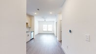 This well-designed one-bedroom, one-bathroom unit offers an efficient and modern single-floor layout. The open-plan living and dining area flows seamlessly from the kitchen, creating a connected and airy feel. Recessed lighting and a ceiling fan complement the natural light admitted through a window at the far end of the living space, while smooth hardwood-style flooring ties the area together cohesively.

The kitchen is thoughtfully equipped with light wood cabinetry, stone-effect countertops, and a full suite of stainless steel appliances including a refrigerator, electric range, built-in microwave, and dishwasher. A dedicated laundry area houses a full-size washer and dryer with overhead wire shelving for additional storage.

The bedroom features plush carpeting, a ceiling fan, and multiple windows fitted with blinds, providing natural light and privacy. A walk-in closet with wire shelving and hanging rods offers generous storage capacity.

The bathroom includes a full tub-shower combination with white tile surround, a curved shower rod, and wood-style flooring, maintaining the clean and contemporary aesthetic found throughout the unit.