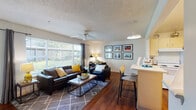 Located at 90 Commons Dr in Eugene, Oregon, this single-floor residence offers a thoughtfully laid-out living space designed for both comfort and functionality. The open-concept living area is a standout feature, showcasing rich hardwood flooring, a ceiling fan, and a textured ceiling. Large windows allow abundant natural light to pour in, offering views of the surrounding greenery and creating a bright, welcoming atmosphere. A breakfast bar with bar seating connects the living area seamlessly to the kitchen, which features cream cabinetry, a stainless steel sink, and included appliances. A conveniently located in-unit laundry room is accessible directly from the kitchen corridor. The bedrooms are carpeted for added comfort; one features a vibrant accent wall, a built-in closet with shelving, a ceiling fan, and a window with outdoor views, while another offers a quieter, more neutral setting. The bathrooms are clean and functional, with one featuring a dual-sink vanity with generous counter space and a large mirror, and another offering a single-sink vanity with additional mirror storage. This residence provides a practical and comfortable living environment in a well-connected Eugene location.