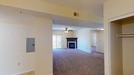 Located at 317 Fourth St S in La Crosse, Wisconsin, this single-floor unit offers a well-organized and functional layout throughout. The open living area is a standout feature, centered around a classic fireplace with a dark surround and mantle, ceiling fan, and sliding glass doors that lead to a private balcony, allowing natural light to fill the space. Plush carpeting extends throughout the living and bedroom areas, adding warmth and comfort underfoot.

The kitchen is designed with practicality in mind, featuring white raised-panel cabinetry, white appliances including a range, microwave, refrigerator, and dishwasher, along with light-toned countertops and a breakfast bar peninsula that opens to the living area. Tile flooring runs through the kitchen and entry areas, providing a clean transition between spaces.

The bedrooms are generously sized, each equipped with ceiling fans and windows that bring in natural light. Ample closet space is present, including a walk-in closet in one of the rooms. Two full bathrooms serve the unit, both finished with tile flooring, white vanities, and shower-tub combinations. A chandelier fixture in the entry area adds a welcoming touch to the space as a whole.