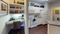 This single-floor residence offers a thoughtfully designed layout across one bedroom and one bathroom. The living room features hardwood-style flooring, crown molding, and neutral walls that create a warm, inviting atmosphere. Natural light filters through draped windows, complementing the cozy seating arrangement.

The dining area, positioned near a windowed entry door with a transom above, features crown molding and hardwood-style flooring, accommodating a round glass-top table suitable for intimate gatherings. Adjacent to the dining space, the kitchen is equipped with white cabinetry, matching appliances, and a built-in nook with open shelving that serves as a convenient home workspace.

The bedroom is carpeted and generously sized, offering two windows with outdoor views of surrounding greenery, a ceiling fan with lighting, and direct access to a spacious walk-in closet with organized shelving and hanging space. The bathroom includes a full tub-shower combination with tile surround, a vanity with countertop sink, and hardwood-style flooring, providing a clean and functional design. Throughout the home, consistent finishes and neutral tones contribute to a cohesive and comfortable ambiance.