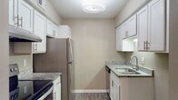 Located at 205 W Montgomery Cross Rd in Savannah, Georgia, this single-floor unit offers a well-appointed and thoughtfully updated interior. The kitchen is a standout feature, showcasing white shaker-style cabinetry with brushed nickel hardware, granite countertops, stainless steel appliances including an electric range and refrigerator, an undermount sink, and durable hardwood-style flooring. The open living area is bright and inviting, featuring the same hardwood-style flooring and a sliding glass door that fills the room with natural light while providing access to an outdoor patio. A dedicated dining area is accented by a modern chandelier, adding an elegant touch to the space. The bedrooms are finished with soft carpeting and neutral-toned walls, with at least one bedroom offering a walk-in closet for generous storage. Natural light filters in through windows, enhancing the comfortable atmosphere. The bathroom is equipped with a full tub-shower combination and clean, functional fixtures. Throughout the unit, textured ceilings, clean white trim, and a warm neutral color palette create a cohesive and welcoming ambiance well-suited for everyday living in the heart of Savannah.
