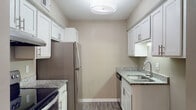 Located at 205 W Montgomery Cross Rd in Savannah, Georgia, this single-floor unit offers a well-appointed and thoughtfully updated interior. The kitchen is a standout feature, showcasing white shaker-style cabinetry with brushed nickel hardware, granite countertops, stainless steel appliances including an electric range and refrigerator, an undermount sink, and durable hardwood-style flooring. The open living area is bright and inviting, featuring the same hardwood-style flooring and a sliding glass door that fills the room with natural light while providing access to an outdoor patio. A dedicated dining area is accented by a modern chandelier, adding an elegant touch to the space. The bedrooms are finished with soft carpeting and neutral-toned walls, with at least one bedroom offering a walk-in closet for generous storage. Natural light filters in through windows, enhancing the comfortable atmosphere. The bathroom is equipped with a full tub-shower combination and clean, functional fixtures. Throughout the unit, textured ceilings, clean white trim, and a warm neutral color palette create a cohesive and welcoming ambiance well-suited for everyday living in the heart of Savannah.
