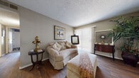 This single-floor residence in Wichita, Kansas offers a well-organized layout encompassing two bedrooms, two bathrooms, a living room, kitchen, hallway, and two closets. The living room serves as the central gathering space, featuring rich hardwood-style flooring, neutral-toned walls, a textured ceiling, and a sliding glass door fitted with vertical blinds that admits natural light and provides outdoor access. The open sightline into the kitchen enhances the sense of connectivity between spaces.

The kitchen is efficiently arranged in a galley configuration, equipped with white cabinetry, light wood-toned countertops, tile flooring, and standard appliances including a refrigerator, range, and dishwasher. A dining nook adjacent to the kitchen features tile flooring and provides a casual space for meals.

The primary bedroom offers carpeted flooring, a window with blinds, a textured ceiling, and access to a walk-in closet with built-in shelving rods. The second bedroom is carpeted and includes a closet. Both bathrooms feature tile flooring, with one bathroom showcasing a tiled tub-shower surround with decorative mosaic accents and a vanity with dark countertops. Throughout, the layout maximizes utility within a compact yet comfortable footprint.