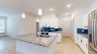 This single-story, 4-bedroom, 2-bathroom home offers a thoughtfully designed layout that balances function and comfort. The open-concept kitchen and living area serves as the heart of the home, highlighted by a large granite-topped island with an undermount sink and pendant lighting overhead. White shaker-style cabinetry, a vibrant blue tile backsplash, and stainless steel appliances — including a French door refrigerator — complete the kitchen's clean, modern aesthetic. Light wood-look flooring runs throughout the main living areas, enhancing the bright, airy atmosphere created by recessed lighting.

The four bedrooms offer a mix of flooring options, with some featuring plush carpet and others continuing the light wood-look floors. Several rooms include ceiling fans and windows with blinds that allow for natural light and ventilation. The primary bedroom connects to a spacious walk-in closet with built-in shelving and hanging rods, providing ample storage.

The bathrooms are finished with granite-topped vanities, white cabinetry, and light wood-look flooring. One bathroom features a tub-shower combo with white subway tile surround and accessibility grab bars. A dedicated laundry room with washer and dryer hookups adds everyday convenience, rounding out this well-equipped home.