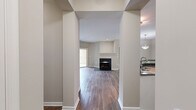This single-floor, 2-bedroom, 2-bathroom residence offers a thoughtfully designed layout with a blend of comfort and modern finishes throughout. The living area is anchored by a striking black-framed fireplace with a classic white mantel, complemented by rich hardwood-style flooring that extends through the main living spaces. Sliding glass doors open to a private balcony, filling the room with natural light and offering pleasant outdoor views.

The kitchen is well-equipped with white cabinetry, dark granite countertops, a tile backsplash, and a full suite of stainless steel appliances, including a range, microwave, dishwasher, and refrigerator. A built-in desk area adds a practical workspace within the kitchen.

Both bedrooms feature plush wall-to-wall carpeting and direct access to outdoor balconies via sliding glass doors. The primary bedroom is served by a spacious en-suite bathroom with dual sinks, a soaking tub, and a separate glass-enclosed shower, as well as a generous walk-in closet with wire shelving systems. The second bathroom features a dual-sink vanity with white cabinetry and a tub-shower combination with tile surround. Neutral tones and clean finishes create a calm, cohesive ambiance throughout the home.