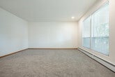 Located at 4716 Regent St in Madison, Wisconsin, this two-bedroom, one-bathroom single-floor unit offers a functional and well-organized layout. The entry hallway, finished with carpet and neutral walls, leads into the main living areas and sets a clean, understated tone throughout the space.

The kitchen is outfitted with white cabinetry offering generous upper and lower storage, light laminate flooring, a double-basin sink, and a white electric range. The kitchen connects to a dedicated dining area, creating a practical combined space for cooking and dining.

The living area is open and airy, with neutral carpet, warm wood baseboards, and a ceiling fan providing comfortable circulation. Natural light filters in through windows with views of mature greenery outside.

Both bedrooms are carpeted and feature warm-toned wood double closet doors, providing ample storage. The primary bedroom includes windows that frame outdoor foliage and a ceiling fan overhead. Each room is well-proportioned and connected via the central hallway.

The bathroom features light wood-tone flooring, a vanity with a stone-pattern countertop, brushed nickel hardware, and clean white fixtures. Multiple closets are distributed throughout the unit, enhancing overall storage capacity. The space presents a practical and tidy residential layout in a convenient Madison location.
