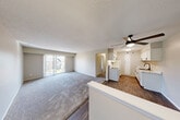 Located at 30361 Timberidge Cir in Farmington Hills, MI, this two-bedroom, one-bathroom unit offers a well-organized single-floor layout that makes efficient use of its space. The living room features plush carpeting, neutral-toned walls, a textured ceiling, and a sliding glass door that opens to a private balcony with outdoor views, filling the room with natural light. Adjacent to the living area, the kitchen stands out with crisp white shaker-style cabinetry accented by matte black hardware, marble-look countertops, a stainless steel sink with a matching black faucet, white appliances, and wood-look flooring — a clean, functional design with a modern touch. The primary bedroom is generously sized, offering ample room and access to a walk-in closet equipped with dual wire shelving systems for organized storage. The second bedroom is carpeted and bright, featuring a window with vertical blinds and a standard closet. Both bedrooms connect through a central hallway. The full bathroom includes a tub-shower combination with a matte black curtain rod and fixtures. Throughout the unit, neutral beige tones and textured ceilings create a cohesive, understated ambiance well-suited for comfortable everyday living.