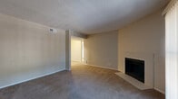 Located at 8711 Cinnamon Creek Dr in San Antonio, Texas, this single-story, two-bedroom, one-bathroom home offers a functional and comfortable layout. The living room serves as the heart of the home, featuring a wood-burning fireplace with a clean white surround, soft carpet flooring, a textured ceiling, and a sliding glass door that fills the space with natural light and provides access to the outdoors. The galley-style kitchen is well-appointed with white cabinetry, light countertops, a stainless steel refrigerator, an electric range, a dishwasher, and a double basin sink — all set atop easy-care tile flooring. A hallway connects the main living areas to the two bedrooms, each carpeted and finished with neutral tones. The spacious primary bedroom offers generous square footage, while the second bedroom features a ceiling fan with light fixture and a window with outdoor views. Four closets throughout the home provide ample storage. The full bathroom includes a tiled tub-shower combination, a vanity with cabinet storage above, and tile flooring. Throughout the home, a consistent neutral color palette and textured ceilings contribute to a cohesive, understated aesthetic.