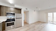 Located on the second floor at 3057 W Pico Blvd. in Los Angeles, this 1-bedroom, 1-bathroom unit offers a clean, modern aesthetic across a well-organized single-level layout. Light wood-tone flooring runs throughout the entire unit, lending warmth and visual continuity to every room.

The open-concept living and dining area is bright and airy, with recessed lighting and sliding glass doors that lead directly to a private balcony — an ideal feature for enjoying the Southern California climate. The kitchen is integrated seamlessly into the main living space, featuring wood-grain cabinetry, a stainless steel appliance package including a refrigerator, range, and dishwasher, and a clean white countertop with an under-mount sink.

The spacious primary bedroom offers a generous footprint, a window that allows natural light to filter in, and direct access to a dedicated closet. The full bathroom maintains the same modern palette, with wood-tone cabinetry, a white countertop vanity, and light wood flooring that carries through from the rest of the unit.

A hallway connects the private areas of the unit to the main living space, providing a logical and functional flow. The consistently white walls and light materials throughout create a bright, neutral environment well-suited for a variety of interior styles.