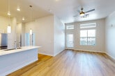 Located at 9191 Nelson Rd in Longmont, Colorado, this well-appointed 4-bedroom, 2-bathroom single-story home offers a clean, modern aesthetic throughout. Light-toned hardwood flooring flows continuously across the entire floor plan, lending a sense of cohesion and warmth to each room.

The open-concept kitchen and living area serves as the heart of the home. The kitchen is outfitted with white shaker-style cabinetry, bright quartz countertops, a stainless steel sink, and a full suite of stainless steel appliances including a range, built-in microwave, dishwasher, and refrigerator. A pendant light above the kitchen island adds a modern touch. The adjacent living room benefits from soaring ceilings, large windows, transom windows above, a ceiling fan, and a glass door that fills the space with natural light and provides outdoor access.

The spacious primary bedroom features elevated ceilings with a ceiling fan, creating an airy retreat. The additional three bedrooms are bright and well-sized, each with windows that invite natural light. Both bathrooms are finished in a crisp white palette, each featuring a tub-shower combination with tiled surround, a vanity with white cabinetry, and wood-tone flooring. A dedicated closet provides added storage convenience throughout this thoughtfully designed home.