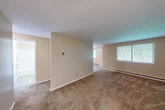 Located at 22 Delano St in Pulaski, New York, this single-floor, 2-bedroom, 1-bathroom residence offers a straightforward and functional layout well-suited for comfortable everyday living. The open living area features neutral beige walls, wall-to-wall carpeting, and baseboard heating units, with multiple windows fitted with blinds that invite natural light throughout the space. The kitchen is a standout feature, showcasing warm oak cabinetry with ample upper and lower storage, white countertops, a double-basin sink, and a white electric range. A peninsula counter extends from the kitchen, providing additional workspace and a natural division between the kitchen and living areas. The light wood-tone flooring in the kitchen adds a clean contrast to the carpeted rooms. Both bedrooms are carpeted and feature neutral tones, baseboard heating, and windows with natural light. The primary bedroom includes a large sliding double-door closet for generous storage. A second closet is also present elsewhere in the unit. The bathroom is clean and functional, featuring a full tub-shower combination with chrome fixtures, a toilet, and light wood-style vinyl flooring. The overall ambiance is bright, neutral, and move-in ready.