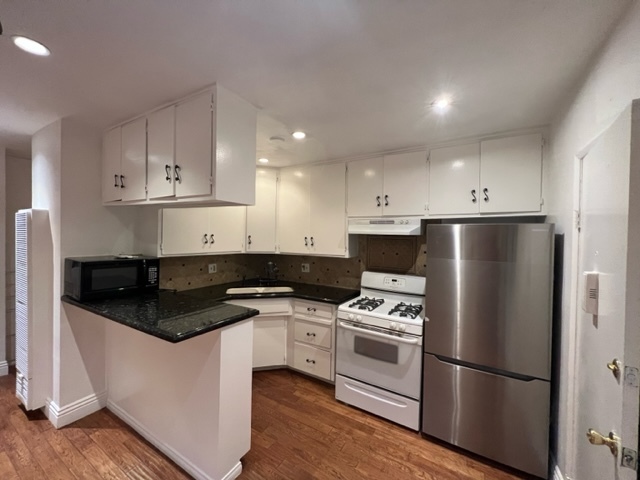 Updated kitchen has stainless steel refrigerator, stove, and lots and lots of cabinet spaces - 5545 1/2 Allott Ave