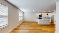 Located at 22 Marcinczyk Ave in Sayreville, NJ, this two-floor home showcases a clean, modern design with consistent finishes throughout. The main level features an open-concept living and kitchen area unified by warm hardwood flooring and recessed lighting. Neutral walls and natural light from blinds-fitted windows create a bright, welcoming atmosphere. The kitchen is well-appointed with crisp white shaker cabinetry, a textured tile backsplash, stainless steel appliances including a gas range and built-in microwave, and a central island with a light quartz countertop and pendant lighting overhead. A dedicated laundry closet with a stacked washer and dryer unit is conveniently accessible from the kitchen area.

The upper floor continues the warm hardwood flooring in common areas, transitioning to plush carpet in the bedrooms. Bedrooms feature sliding panel doors that open to closets with built-in rod and shelf systems. The bathrooms are finished with large-format floor tiles, white subway tile surrounds, and matte black fixtures. One bathroom includes a soaking tub, while another offers a glass-enclosed walk-in shower with a built-in bench, adding a refined, spa-like touch to the space.