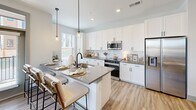 Located at 2500 Pelham Rd in Greenville, SC, this 2-bedroom, 1-bathroom residence offers a thoughtfully designed single-floor layout with modern finishes and a bright, welcoming atmosphere. The entryway features a built-in coat rack with a shelf, setting a functional and stylish tone from the moment you arrive.

The open-concept living and dining area is anchored by light wood-style flooring, a ceiling fan, and large windows dressed with sheer curtains that invite generous natural light and outdoor views. The kitchen is a standout, showcasing white shaker cabinetry, grey quartz countertops, a white subway tile backsplash, and a full suite of stainless steel appliances. A peninsula with bar seating and pendant lighting adds both functionality and a social dining element.

The primary bedroom is a comfortable retreat with carpet flooring, a ceiling fan, and a window overlooking the outdoors. It features direct access to the bathroom, which is finished with a white vanity, grey countertop, and framed mirror. The second bedroom mirrors the same calm aesthetic with its own ceiling fan and closet. Notably, the unit includes six closets, providing exceptional storage throughout. A dedicated laundry area completes this well-rounded and efficiently designed home.