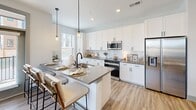 Located at 2500 Pelham Rd in Greenville, SC, this 2-bedroom, 1-bathroom residence offers a thoughtfully designed single-floor layout with modern finishes and a bright, welcoming atmosphere. The entryway features a built-in coat rack with a shelf, setting a functional and stylish tone from the moment you arrive.

The open-concept living and dining area is anchored by light wood-style flooring, a ceiling fan, and large windows dressed with sheer curtains that invite generous natural light and outdoor views. The kitchen is a standout, showcasing white shaker cabinetry, grey quartz countertops, a white subway tile backsplash, and a full suite of stainless steel appliances. A peninsula with bar seating and pendant lighting adds both functionality and a social dining element.

The primary bedroom is a comfortable retreat with carpet flooring, a ceiling fan, and a window overlooking the outdoors. It features direct access to the bathroom, which is finished with a white vanity, grey countertop, and framed mirror. The second bedroom mirrors the same calm aesthetic with its own ceiling fan and closet. Notably, the unit includes six closets, providing exceptional storage throughout. A dedicated laundry area completes this well-rounded and efficiently designed home.