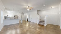 Located in San Antonio, TX, this two-story, 3-bedroom, 3-bathroom home offers a thoughtfully designed layout spread across two floors. The main level features striking polished concrete floors that flow throughout the open-concept living and dining areas, complemented by crisp white walls, crown molding, recessed lighting, and ceiling fans. Multiple windows with blinds flood the space with natural light, creating a bright and airy atmosphere. The kitchen is well-appointed with white shaker-style cabinetry, granite countertops, a subway tile backsplash, stainless steel appliances including a refrigerator, range, microwave, and dishwasher, and pendant lighting over a breakfast bar. A pantry and laundry room add functional convenience on this level. The staircase leads to the upper floor, where plush carpeting runs through all three bedrooms. The generously sized primary bedroom includes a walk-in closet with built-in double hanging rods. Additional bedrooms are bright with multiple windows and ceiling fans. The three bathrooms are clean and functional, with one featuring a tub-shower combo, wood-look flooring, and a vanity with brushed nickel hardware. Three closets throughout the home provide ample storage.