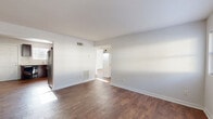 Located in Atlanta's 30318 zip code, this two-bedroom, one-bathroom single-floor residence offers a straightforward and functional layout. Rich, wood-look flooring runs consistently throughout the home, anchoring each room with warmth against the clean white walls and trim.

The living room is a bright, open space with neutral tones, a wall-mounted electrical panel, and easy flow into the adjacent kitchen. The kitchen is well-equipped with dark espresso cabinetry, light countertops, a stainless steel refrigerator, black electric range, dishwasher, and a window above the sink that brings in natural light. A door in the kitchen provides direct exterior access.

The primary bedroom is generously proportioned and features a dual closet, providing ample storage. The second bedroom benefits from a large window with natural light and its own closet. A connecting hallway ties the bedrooms and bathroom together efficiently. The bathroom includes a full tub-shower combination with white subway tile surround and a window for ventilation.

Additional spaces include a utility room and multiple closets distributed throughout the home. The consistent flooring, neutral palette, and practical layout make this a well-organized residence in Atlanta.