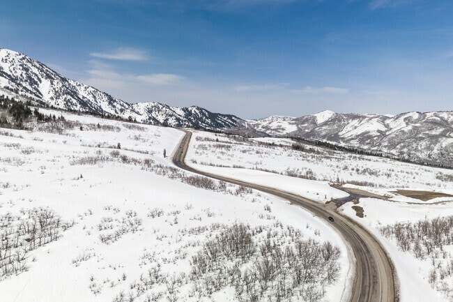 Snowbasin Rd cutting through snowy mountains, in the Snowbasin Resort.