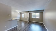 Located at 3900 Gateway Drive in Philadelphia, PA, this one-bedroom, one-bathroom unit offers a well-organized single-floor layout designed for comfortable everyday living. The open living and dining area is finished with durable dark wood-style flooring and features multiple windows that invite natural light throughout the space. A ceiling fan adds practicality to the living area, while neutral taupe walls create a clean, cohesive aesthetic.

The kitchen is a standout feature, equipped with rich dark cabinetry, light quartz countertops, a tile backsplash, and black appliances including a refrigerator, gas range, and built-in microwave. A white peninsula with an integrated sink provides additional prep space and naturally defines the boundary between the kitchen and living areas.

The bedroom is carpeted for warmth and comfort, offering a quiet retreat with a window overlooking greenery. It includes two sliding-door closets, providing generous storage. A hallway connects the main living spaces to the bathroom and a utility room, adding functional flow to the layout.

The bathroom is tastefully finished with a soaking tub surrounded by white subway tile and accented by a decorative mosaic border in warm earth tones. Together, these details reflect a thoughtfully updated interior with a modern yet practical character.