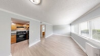 This one-bedroom, one-bathroom unit at 1914 Generation Drive in Raleigh, NC offers a thoughtfully laid-out single-floor living space with a clean, neutral aesthetic throughout. The living room serves as the heart of the home, featuring light wood-style luxury vinyl flooring, soft gray walls, crown molding, and a textured ceiling. Natural light filters in through blinded windows, creating a bright and welcoming atmosphere. A closet near the entry provides convenient storage just inside the front door.

The kitchen is well-appointed with warm honey-toned wood cabinetry, dark granite-style countertops, a stainless sink, and black appliances including an electric range with overhead exhaust. Light flooring ties the kitchen seamlessly to the main living area.

The spacious bedroom offers plush wall-to-wall carpeting, soft gray walls, a textured ceiling, and a window that brings in natural light. The room provides ample space for a full bedroom suite with room to spare.

The full bathroom features warm wood-toned cabinetry with a white countertop, a full tub-shower combo with clean white surround, a toilet, and wood-look tile flooring. A hallway connects the main spaces efficiently, completing this well-organized and comfortable Raleigh residence.