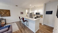 Located at 3999 Highland Crest Way in Knoxville, Tennessee, this single-floor, three-bedroom, three-bathroom home offers a well-designed layout built for comfortable everyday living. The open-concept kitchen and living area serves as the heart of the home, featuring a large peninsula with bar seating, white raised-panel cabinetry, stainless steel appliances including a refrigerator, microwave, and range, and wood-look flooring that extends throughout the common areas. The living room is bright and inviting, highlighted by elegant arched windows that bring in natural light and crown molding that adds a refined architectural touch. Each of the three bedrooms is carpeted for comfort, includes a ceiling fan, and is paired with its own dedicated bathroom and closet. The bathrooms are finished with wood-look tile flooring, white vanities with solid countertops, and full tub-shower combinations. A dedicated laundry room with a washer and water heater provides added convenience. Three closets offer generous storage throughout the home. The neutral color palette and clean finishes create a cohesive, move-in-ready aesthetic throughout this well-appointed Knoxville residence.