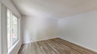Located at 2590 Capitals Dr in Rancho Cordova, CA, this one-bedroom, two-bathroom residence offers a well-organized single-floor layout designed for comfortable everyday living. The combined kitchen and living area forms the heart of the home, with light wood-look vinyl flooring running throughout and a ceiling fan overhead. The kitchen is equipped with white cabinetry, warm-toned countertops, a full suite of white appliances including a refrigerator, dishwasher, and electric range, and a window that brings in natural light and outdoor greenery views. The spacious bedroom features plush wall-to-wall carpeting, neutral gray walls, a textured ceiling, and a generous window that fills the room with natural light. A dedicated closet provides practical storage. The two bathrooms are clean and functional — one features a wide vanity with warm-toned countertops, white cabinetry, and wood-look flooring, while the second includes a full bathtub and shower combination. Throughout the unit, crisp white trim, neutral tones, and consistent flooring choices create a cohesive, move-in-ready aesthetic that is both practical and welcoming.