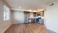Located in National City, CA, this well-appointed two-bedroom, two-bathroom residence offers a thoughtfully designed single-floor layout. The open-concept kitchen and living area serves as the heart of the home, featuring rich wood-style flooring, recessed lighting, and a clean, modern aesthetic. The kitchen is equipped with a full suite of stainless steel appliances — including a refrigerator, gas range, built-in microwave, and dishwasher — complemented by warm-toned cabinetry and granite-style countertops that provide ample prep and storage space.

Both bedrooms are generously sized with the same warm wood-style flooring, neutral wall tones, and large windows that invite natural light. The primary bedroom offers direct access to a private balcony with outdoor views, while the second bedroom features multiple windows for bright, airy comfort. Each bedroom includes closet storage. A hallway connects the private quarters to the rest of the home.

Both bathrooms are finished with white subway tile tub/shower surrounds, chrome fixtures, and wood-style flooring, maintaining a clean and consistent design throughout. The overall ambiance of the residence is modern, bright, and move-in ready.